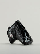 Black quilted leather golf headcover with small icon of embroidered lips clutching a golf tee.