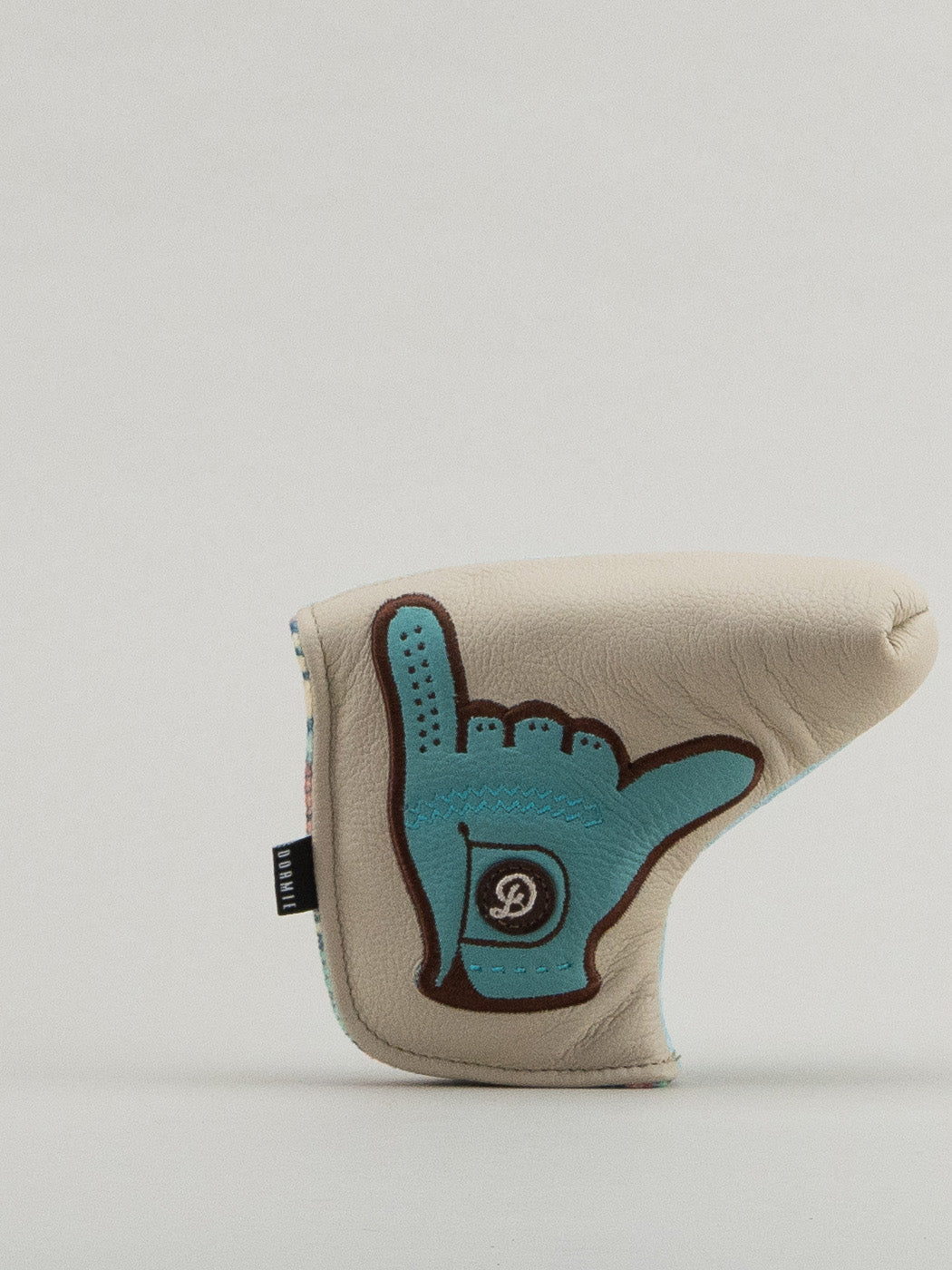 Beige and blue golf club headcover with a glove holding the shaka up